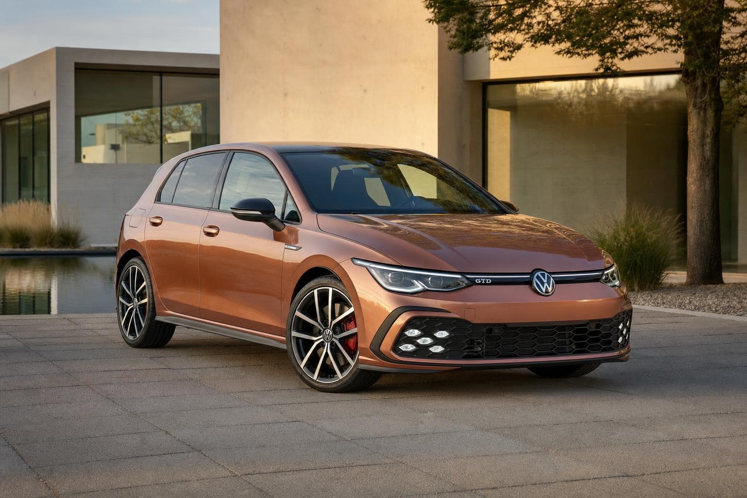 Koperkleurige Volkswagen Golf 8 GTD voor een modern huis met warme natuursteen